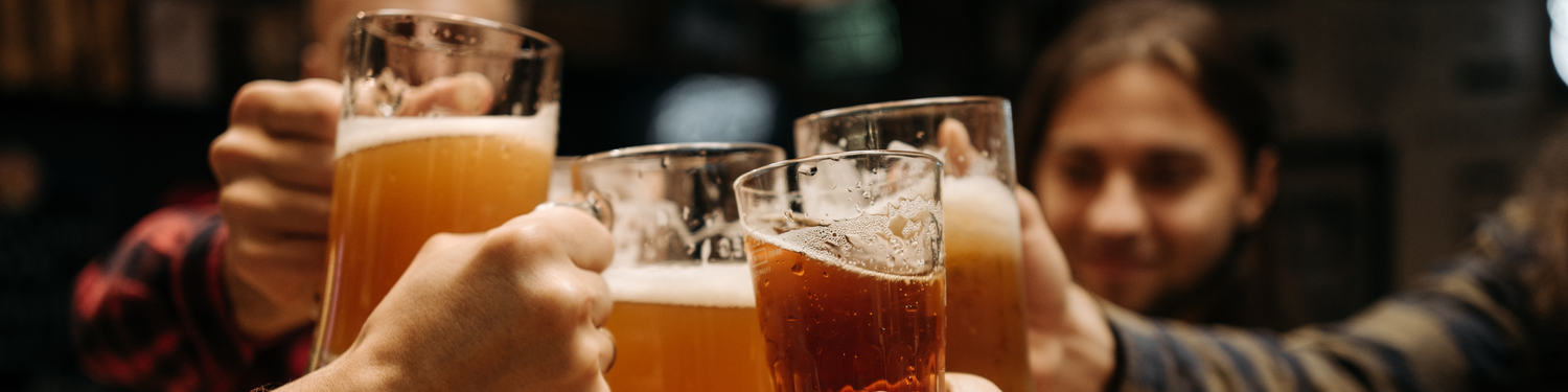 Four close friends toast with glasses of beer