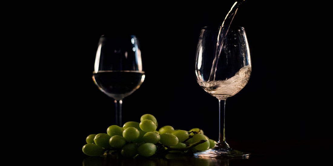 Two Glasses Of White Wine And Green Grapes